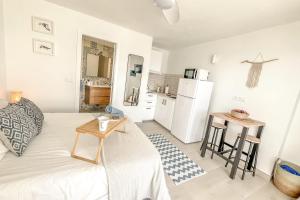 a white room with a bed and a kitchen at Casa Burgao Studio with large seaview terrace in Punta de Mujeres +16 photos