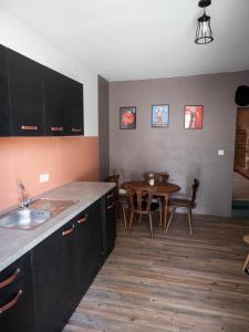 a kitchen with a sink and a table with chairs at Appartement rénové sur le thème du Far West in Soyaux