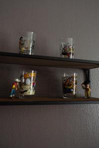 a wooden shelf with some glasses on it at Appartement rénové sur le thème du Far West in Soyaux