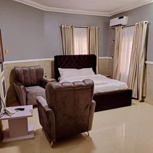 Un dormitorio con una cama, un sofá y una silla. en International royal hotel, en Owerri