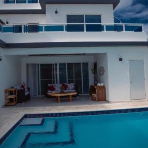 a house with a swimming pool in front of a house at Red Heart 3 Bedrooms Villa in Sosua
