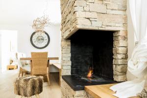 a living room with a stone fireplace at Alpine Chic Apartment in Andermatt +26 photos