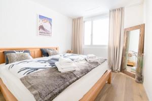 a bedroom with a large bed with towels on it at Alpine Chic Apartment in Andermatt