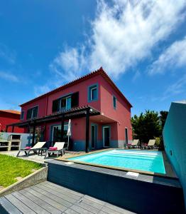 a house with a swimming pool in front of it at Sunset Dreams - Arco da Calheta in Arco da Calheta