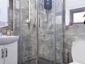 a shower with a glass door in a bathroom at Heddfan - Uk47835 in Llanboidy