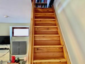 a wooden staircase in a room with a book shelf at Heddfan - Uk47835 in Llanboidy +5 photos