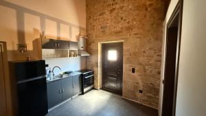 a kitchen with a black door and a black refrigerator at Stone House Experience in Voúvai
