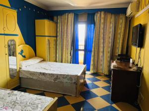 a room with two beds and a tv in it at Cairo 1890 in Cairo