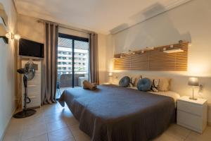 a bedroom with a large bed and a large window at El Teide Apartment with Pool & Balcony in Puerto de Santiago