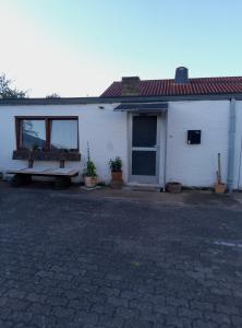 a white house with a bench in front of it at Schönes Studio Appartment in Saarlouis