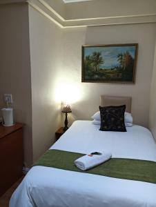 a bedroom with a white bed with a pillow at Table Mountain Guesthouse in Malmesbury