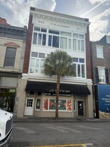 a building with a palm tree in front of it at Downtown Charleston Condo in Charleston