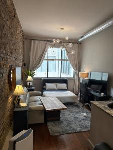 a living room with a couch and a piano at Downtown Charleston Condo in Charleston