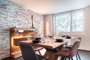 a dining room with a table and chairs and a fireplace at Casa Zopa in Andermatt
