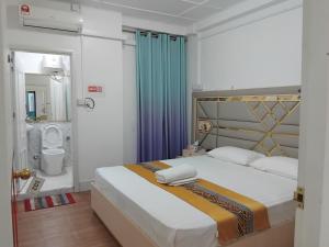 a hotel room with a bed and a bathroom at Ontrack Travel in Male City
