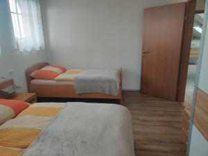 a small room with two beds and a door at Ferienwohnung Oberreiter in Sandl