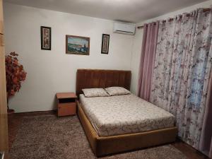 Habitación pequeña con cama y cortina en Cosy House, en Tirana 3 fotos más