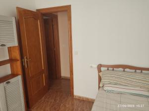 a bedroom with a bed and an open door at La casa del abuelo in Ítrabo