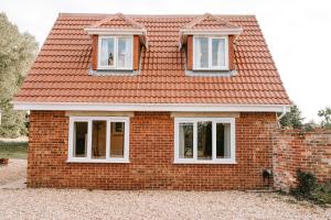 a red brick house with white windows on it at Romantic Country Cottage with Private Hot Tub in Rowde