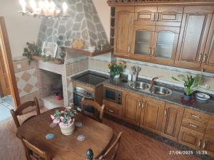 a kitchen with a wooden table and a fireplace at La casa del abuelo in Ítrabo
