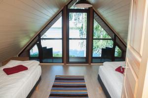 two beds in a room with large windows at Karujärve Camping in Paiküla