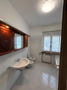Un baño con dos lavabos y un inodoro. en Lake side and view - new bright apartment, en Lecco