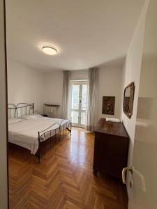 Un dormitorio con una cama y suelo de madera. en Lake side and view - new bright apartment, en Lecco 23 fotos más