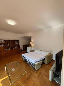 Un dormitorio con una cama, un televisor y una mesa. en Lake side and view - new bright apartment, en Lecco