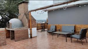 a patio with chairs and a white screen on a brick building at Carlos Paz Hostel Lodge in Villa Carlos Paz