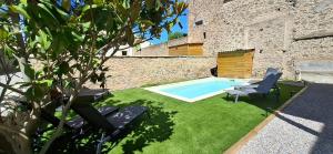 a yard with a swimming pool and two chairs at Les Gîtes de Monte Blanco - Chambres d'hôtes et gîtes in Montblanc