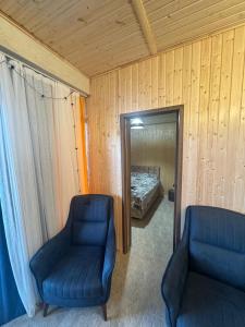 a bedroom with a bed and two chairs and a mirror at Tsikhisdziri Home in Tsikhisdziri