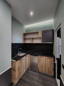 Una cocina con gabinetes de madera y electrodomésticos de acero inoxidable. en Aura Hotel, en Durrës 11 fotos más