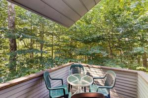 Una mesa y sillas en un porche con árboles. en The Wolf Den, en Lincoln