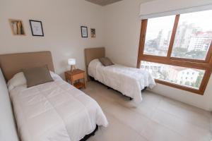 a bedroom with two beds and a window at Frente al mar in Pinamar +14 photos