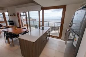 a kitchen with a table and a view of the ocean at Frente al mar in Pinamar