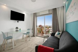 ein Wohnzimmer mit Sofa und Tisch in der Unterkunft Cute Studio In The Sun in Puerto de la Cruz