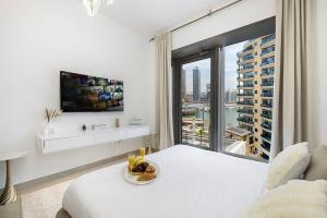 a white bedroom with a large window and a bed at Sparkle Tower by Swarovski, Full Marina View, 2min JBR & Metro, Sleeps 4 in Dubai
