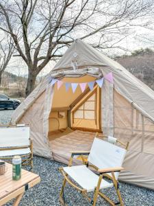 a tent with two chairs and a table at Bertinus Medieval Lodge Camping in Serra Negra