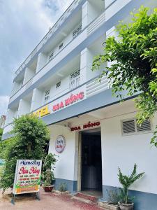 a white building with a sign in front of it at Homestay Hoa Hồng in Liên Trì (4)
