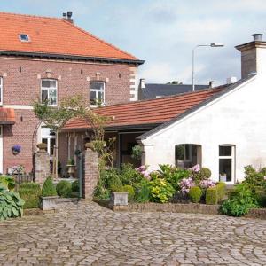 a house with a brick driveway in front of a building at Ferrum Ferrum in Valkenburg