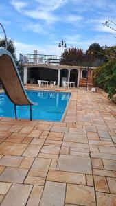 a bench sitting on a patio next to a swimming pool at Casa de temporada 2 in Serra Negra