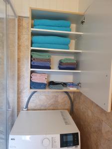 a laundry room with a washing machine and towels at Feriehus med utsikt mot fjellet Hoven in Smedvik +17 photos