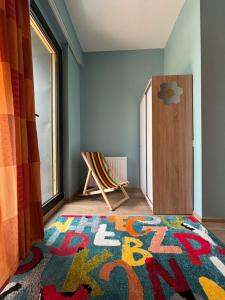 a room with a rug and a chair and a window at Sama Bakuriani in Itʼkhvisi