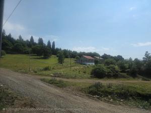 a dirt road with a house in the middle of a field at Sama Bakuriani in Itʼkhvisi