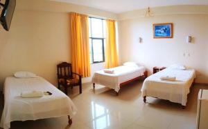ein Hotelzimmer mit zwei Betten und einem Fenster in der Unterkunft Tahuari Hotel in Pucallpa