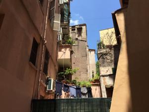 ローマにあるInside Trastevere, Apt with terraceの二棟の間の路地に物干し場