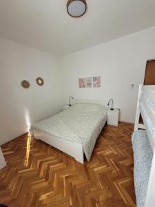 a bedroom with a bed and a wooden floor at Apartment Kaktus in Pirovac +13 photos