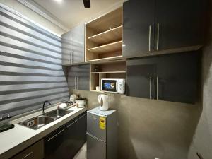 a small kitchen with a sink and a microwave at Jayda Lodge in Kwedonu