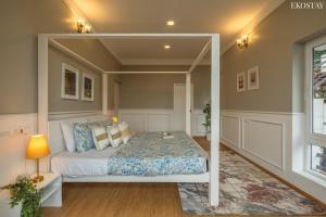 a bedroom with a bed with a canopy at EKOSTAY I Pearl House Villa I 360 Degrees Tea Estate in Ooty +24 photos