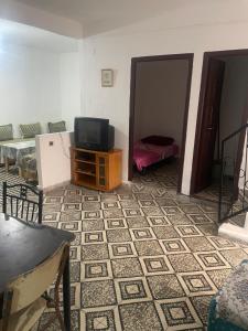 a living room with a tv on a table and a floor at Catalan in Martil
